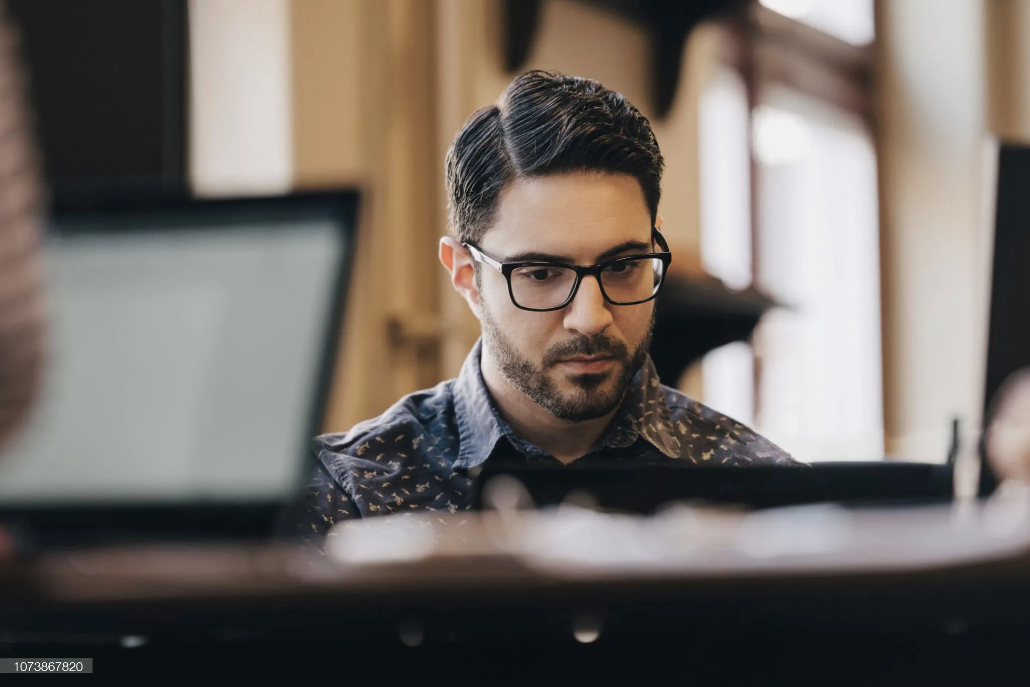 Mann mit Brille arbeitet an einem PC